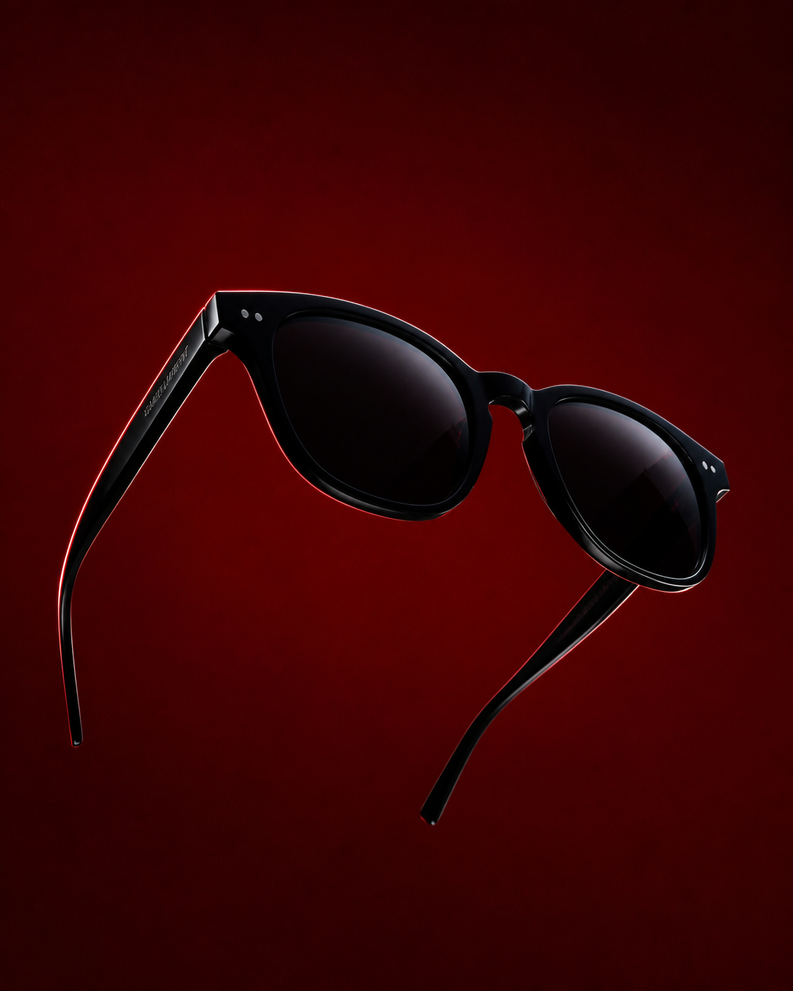 Black acetate sunglasses floating against a deep crimson backdrop