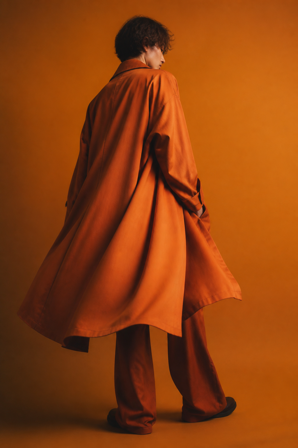 Velmara — fashion editorial, burnt-orange coat on amber backdrop